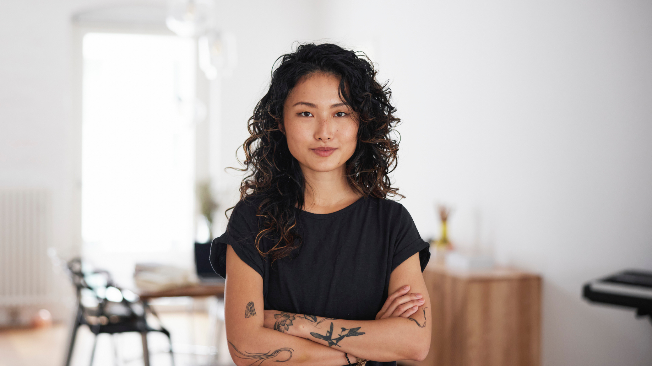 Young Asian Woman Smiling with Arms Crossed